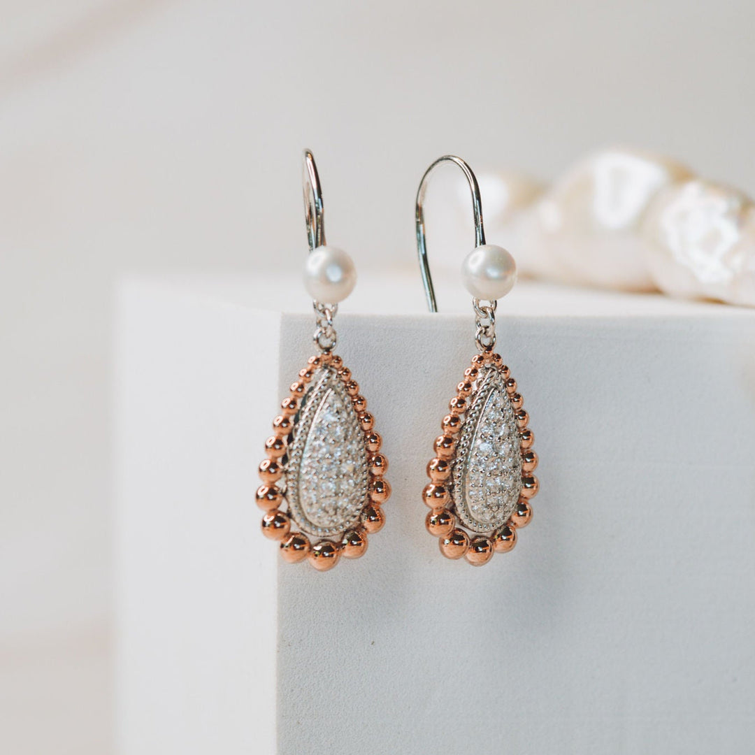 The Grace Earrings are a timeless essential, designed to bring effortless elegance to everyday wear. Featuring classic hook settings accented with sparkling cubic zirconia and finished with a luminous pearl, these refined earrings beautifully balance simplicity and sophistication. A versatile staple for any fine jewellery collection, the Grace Earrings offer enduring style with a polished, graceful finish.