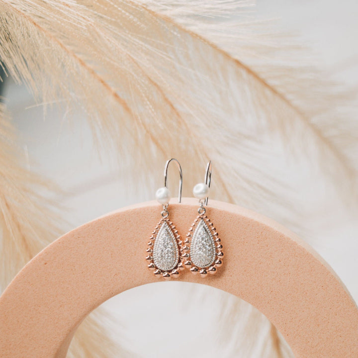 The Grace Earrings are a timeless essential, designed to bring effortless elegance to everyday wear. Featuring classic hook settings accented with sparkling cubic zirconia and finished with a luminous pearl, these refined earrings beautifully balance simplicity and sophistication. A versatile staple for any fine jewellery collection, the Grace Earrings offer enduring style with a polished, graceful finish.