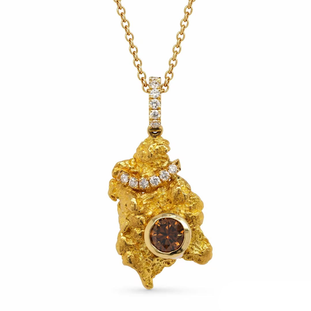 A gold pendant necklace featuring a textured gold mount with a central round brown gemstone and a curved row of small clear stones, suspended from a gold chain on a white background.