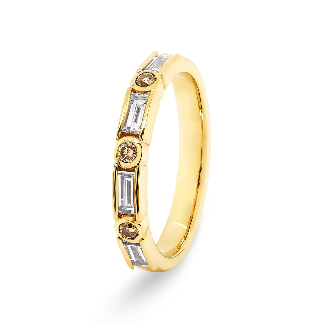 A yellow gold eternity-style ring featuring baguette-cut clear Champagne diamonds and round-cut brown champagne diamonds, shown on a clean white background.