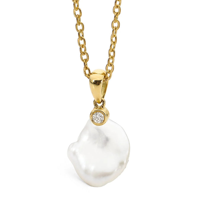 The Elsie Pendant captures elegance in every unique curve. Showcasing the natural beauty of an organic Keshi pearl and accented by a brilliant diamond stud, this pendant embodies refined sophistication. Perfectly suited for any occasion—whether formal, casual, or bridal—it’s a stunning piece that makes a lasting impression.