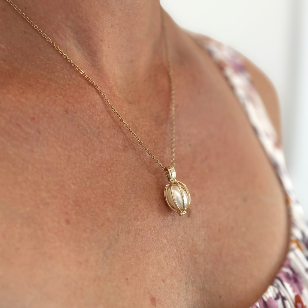 Timeless and sophisticated, the Celia Pendant features an openable 9ct yellow gold cage designed to showcase a white Freshwater pearl. The polished structure frames the pearl beautifully, allowing its natural lustre to shine from every angle.

Its hinged opening allows you to easily interchange the pearl, offering versatility for every occasion. A delicate and refined piece for lovers of classic pearl jewellery.