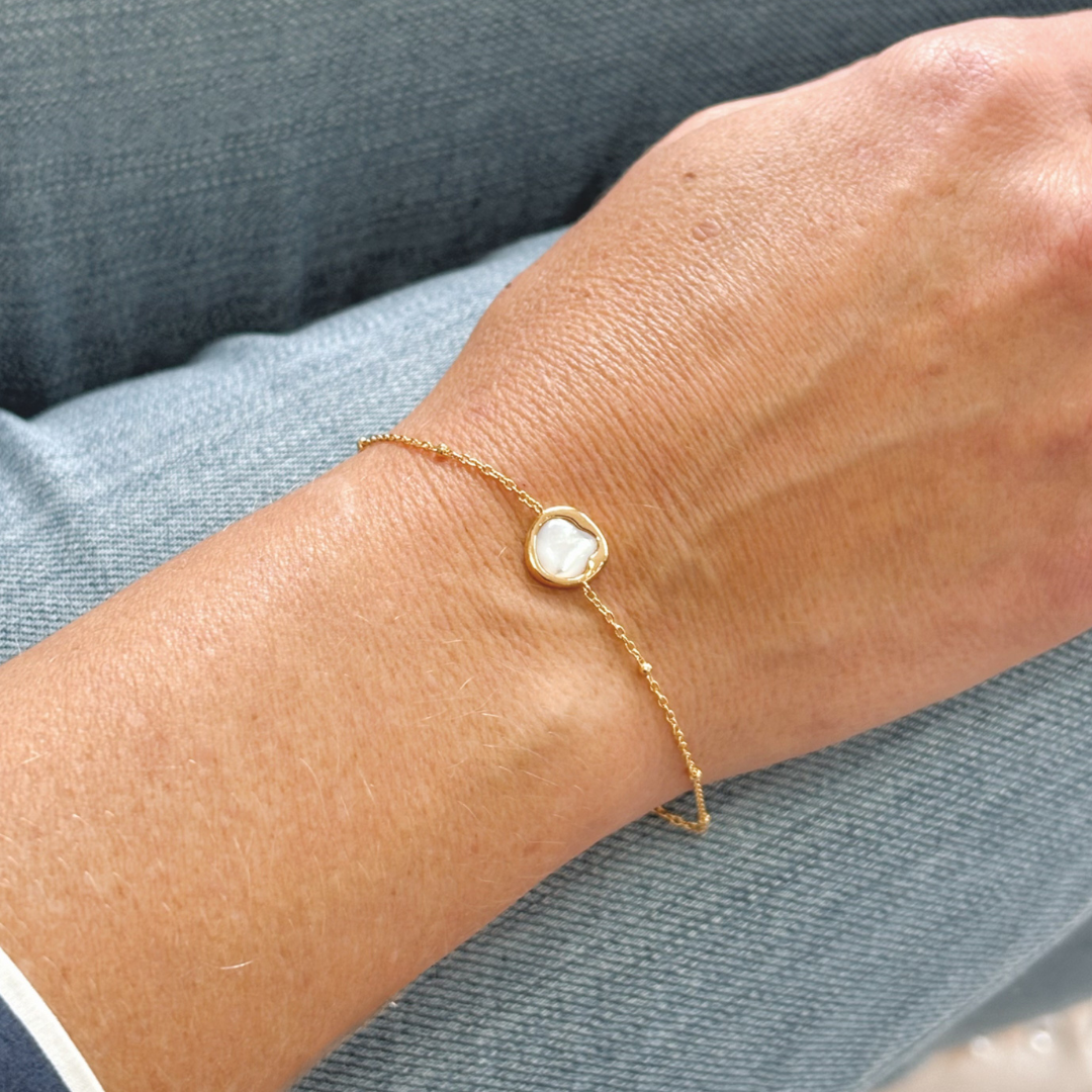 Refined and radiant, the Kiara Bracelet features a uniquely shaped white Mother of Pearl charm set in yellow gold-plated sterling silver. Designed on a delicate chain, this piece adds a soft, luminous touch to the wrist — perfect worn alone or layered with your everyday favourites.