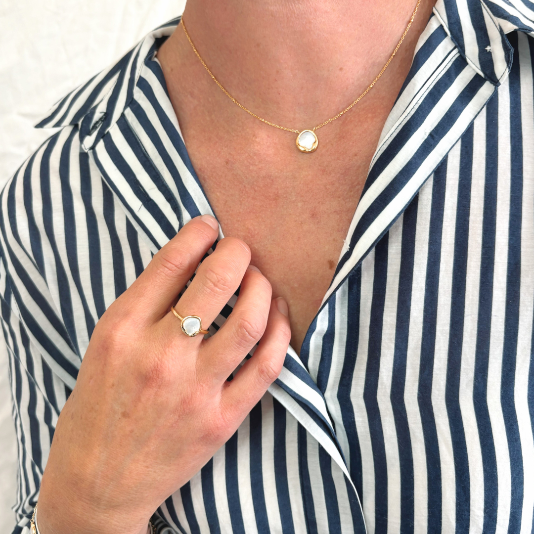 Elegant and effortless, the Kiara Necklace features a uniquely shaped white Mother of Pearl pendant set in yellow gold-plated sterling silver. Suspended on a chain, this piece brings a soft, luminous glow to any neckline — perfect for layering or wearing solo as a subtle statement.