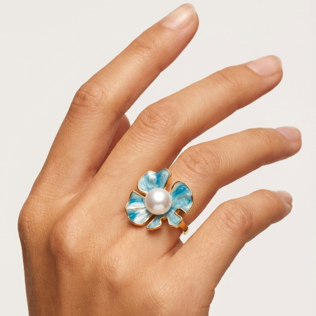 The Posie Ring is a joyful celebration of colour and craftsmanship, crafted in sterling silver with warm yellow gold plating and finished with delicate enamel petals. At its centre sits a luminous white button freshwater pearl, glowing softly against the vibrant enamel and golden tones. Inspired by blooming florals, this design feels playful yet refined, balancing timeless pearl elegance with a fresh, modern twist. 