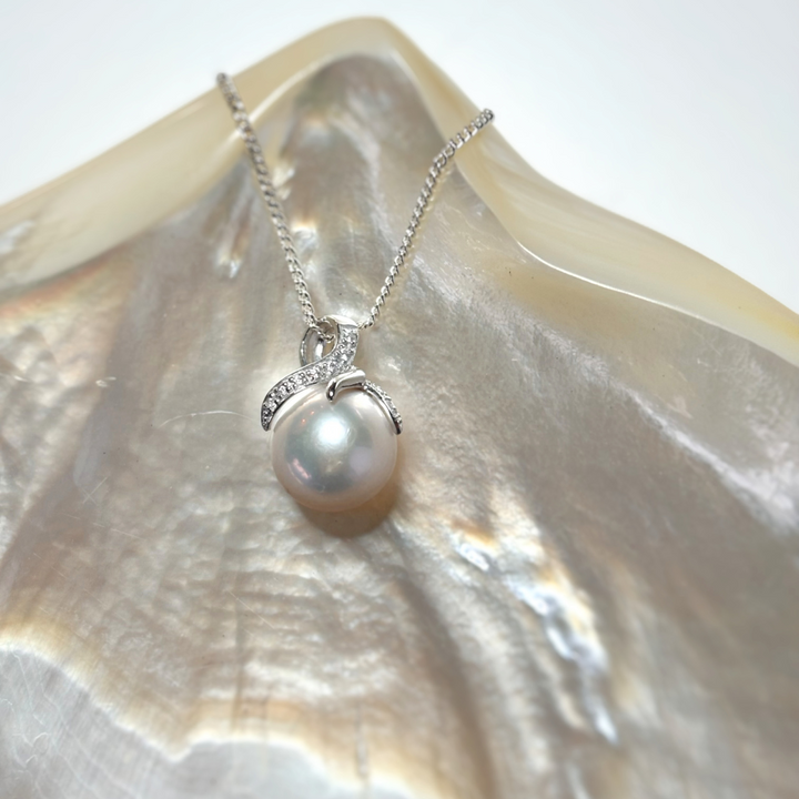 Graceful and refined, the Estelle Pendant showcases a luminous white Edison freshwater pearl cradled in a contemporary claw setting. Sparkling cubic zirconia accents curve gently around the pearl, adding a modern touch to this timeless piece. Crafted in sterling silver, it&