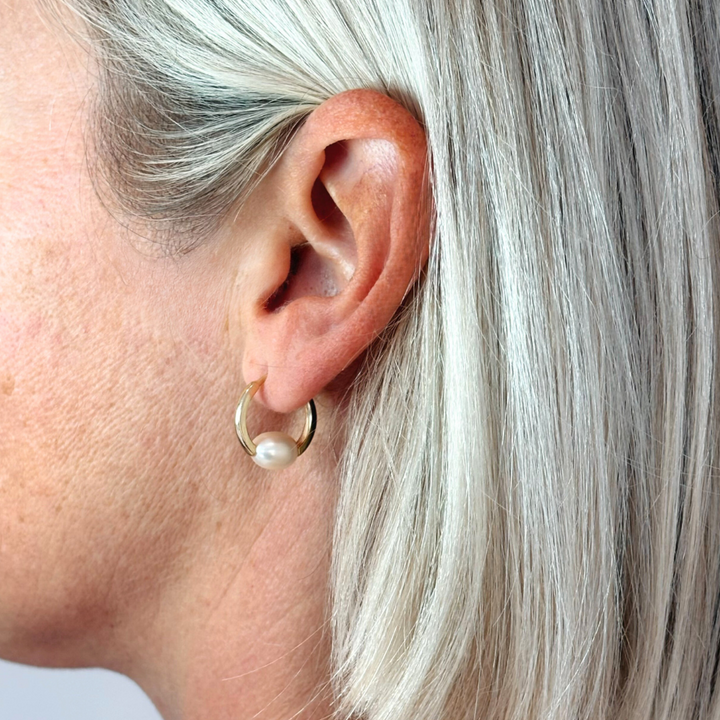 Elegant and versatile, the Freya Hoops feature lustrous oval freshwater pearls resting securely within the curve of the hoops. Their classic yet modern design makes them perfect for effortless, everyday style or elevating a special occasion look. Lightweight and timeless, these pearl hoops are a must-have staple for any jewellery collection.